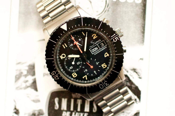 Stainless steel Sinn 156 pilot chronograph with black dial, day-date display, and rotating bezel.