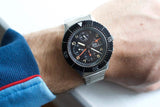 Vintage Sinn 156 pilot chronograph with black dial, tritium markers, and steel bracelet on wrist