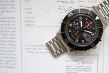 Sinn 156 pilot chronograph luxury watch with stainless steel bracelet on document background
