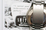 Close-up of stainless steel luxury watch bracelet clasp with engraved S on a vintage ad background