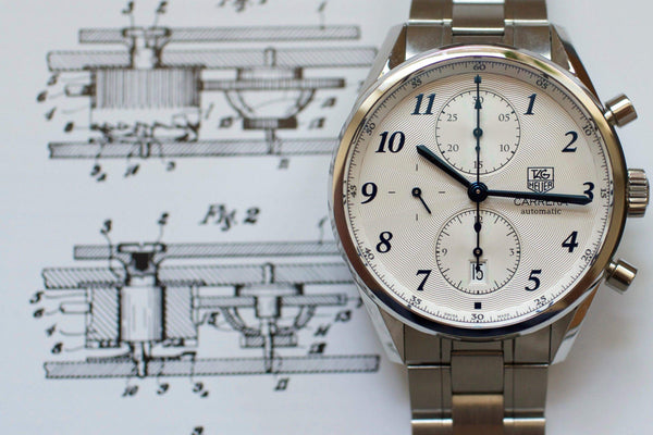 Luxury stainless steel chronograph watch with white dial on technical blueprint background