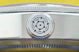 Close-up of a luxury stainless steel watch crown with engraved rose emblem