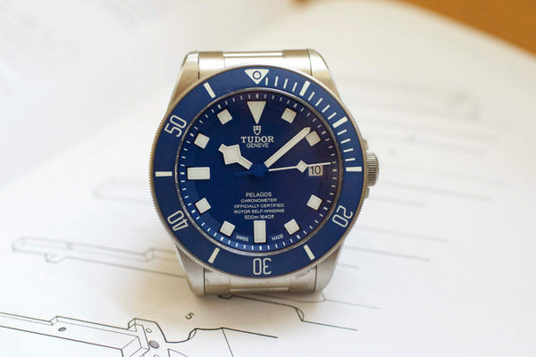 Blue dial Tudor Pelagos titanium dive watch with stainless steel bracelet on white background