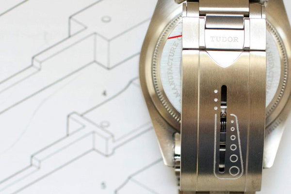 Close-up of Tudor Pelagos titanium watch clasp and caseback on technical drawing background