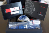 Blue dial Tudor Pelagos luxury watch with box, warranty card, extra strap, and manuals