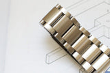 Close-up of stainless steel luxury watch bracelet on white background