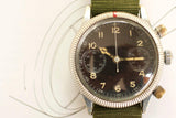 Vintage pilot chronograph watch with black dial, luminous hands, and green NATO strap