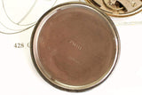 Close-up of vintage watch case back with engraved serial numbers and inner watch mechanism