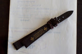Brown leather watch strap with gold Vacheron Constantin logo, placed on paper background