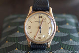 Vintage gold Swiss watch with black leather strap and Roman numeral markers