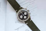 Vintage chronograph watch with black dial and green leather strap on technical drawing