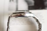 Close-up side view of a vintage stainless steel luxury watch case and bracelet