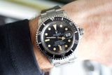 Vintage Rolex Submariner 1680 luxury watch with black dial and steel bracelet on wrist
