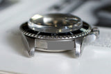 Close-up of vintage stainless steel diver watch case with domed crystal and rotating bezel