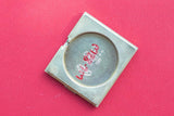 Close-up of a square metal watch case back with Rolex Geneva Switzerland engraving.
