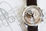 Zenith El Primero chronograph luxury watch with open-heart dial and brown leather strap on technical drawing background