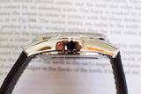 Side view of polished stainless steel luxury chronograph watch with black leather strap
