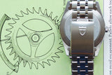 Back view of a luxury Swiss-made watch resting on a technical gear diagram.