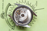 Close-up of a Tudor luxury watch movement placed on a technical drawing of gears.