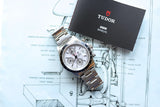 Tudor chronograph luxury watch with user manual on a technical watch movement diagram