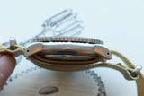 Side view of a luxury Swiss watch with a beige fabric strap.