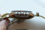Side view of a luxury chronograph watch with a tan fabric strap.